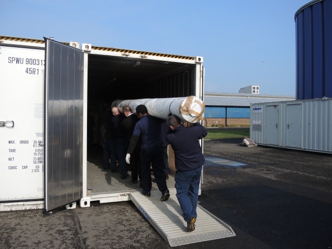 The team moving the very heavy rolled tapestry into the walk in freezer unit