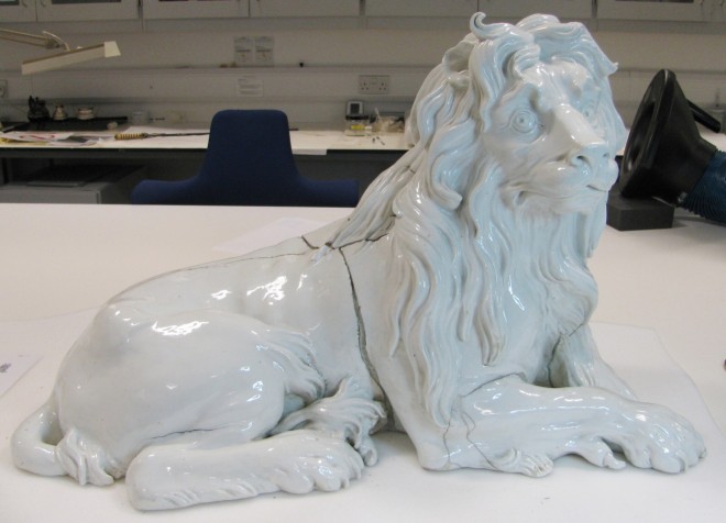 The metre-long porcelain lion on the workbench before conservation 