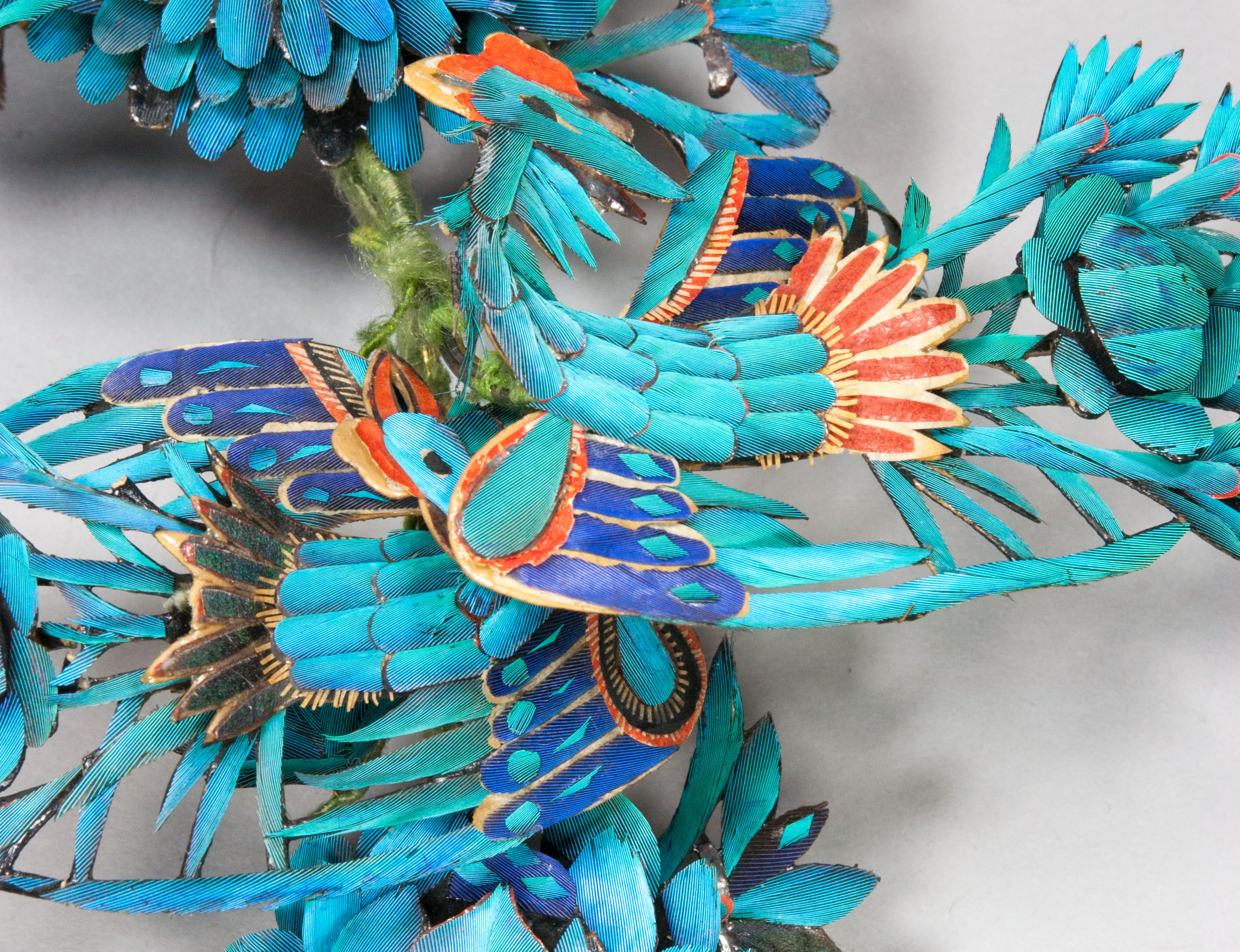 Detail of phoenixes, decorated with kingfisher feathers, red and gold paper. Supporting wires are seen wrapped in green silk.