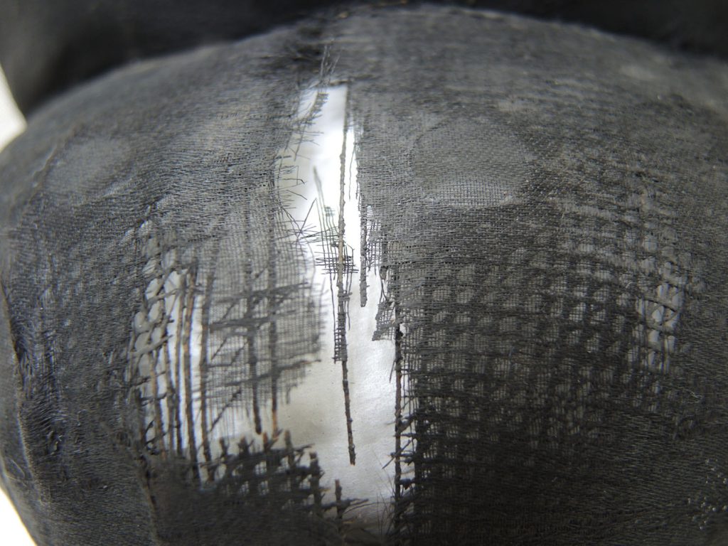Detail of the damage at the front of the hat.
