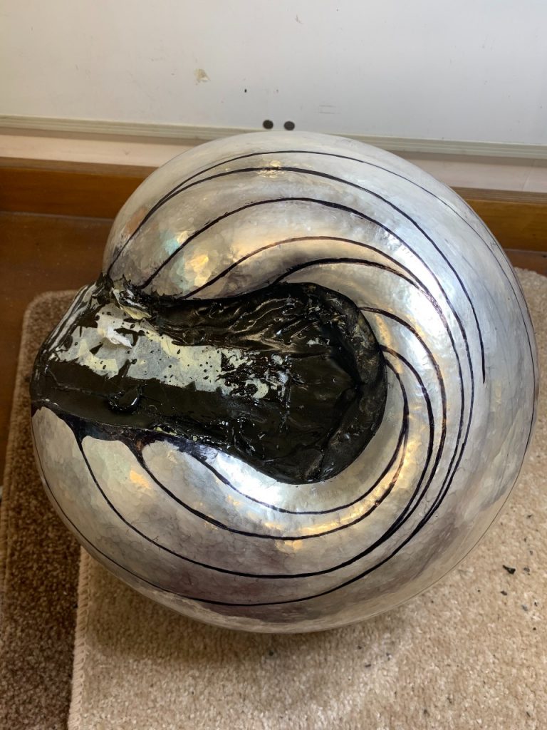 The sculpture is now looking like a rounded wave - almost like a 'C' shape. The cavity in the middle of the sculpture is filled with a black tar-like substance 