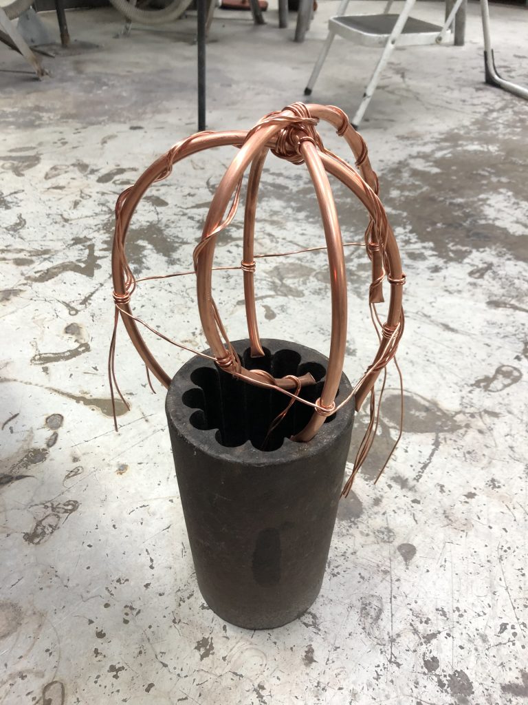 Copper pipes and wire sitting in a metal pot ready for glass.