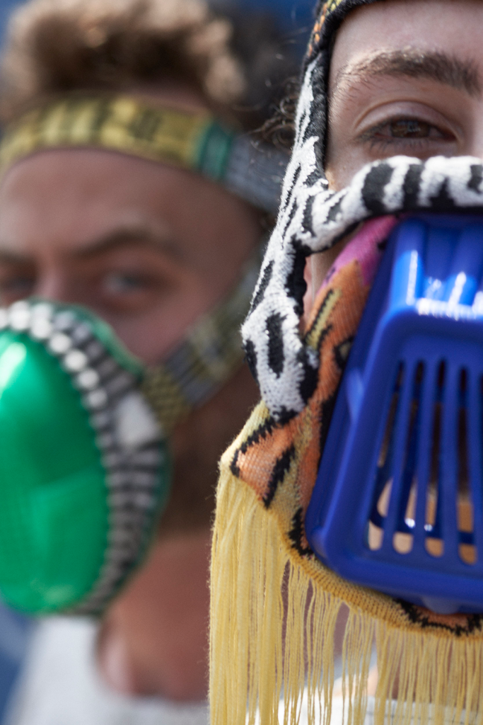 Close-up of two people in colourful face coverings.