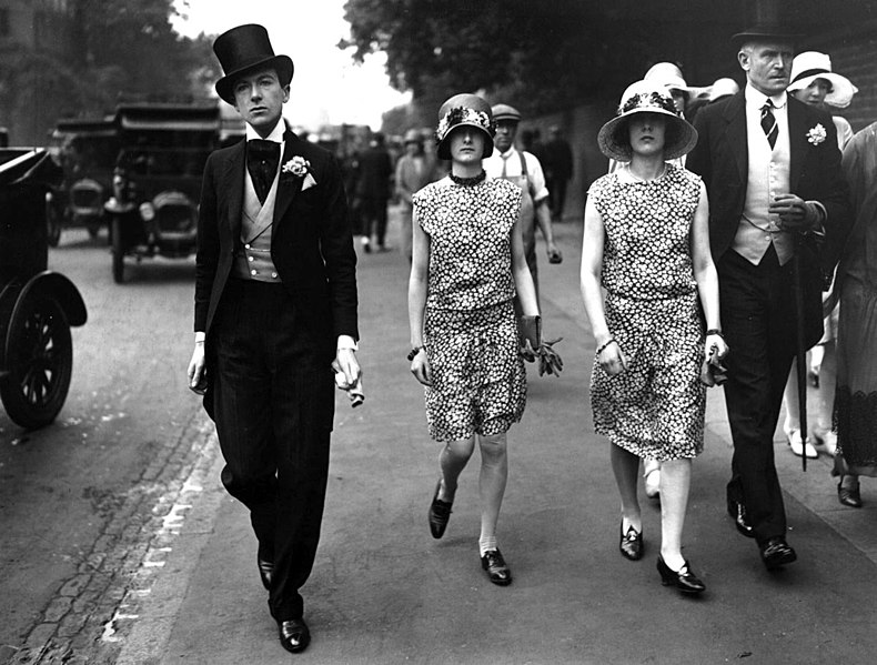 Black and white photo of people in the 1930s walking down a road. 