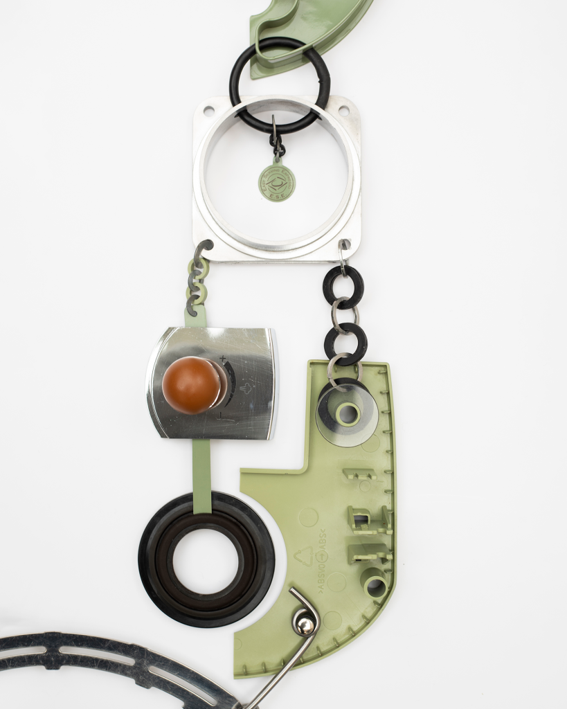 A coffee machine deconstructed into constituent parts. and made into a necklace.