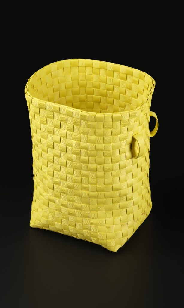 Tall, rectangular yellow basket against a black background.