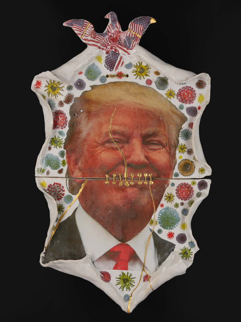 Ceramic plate with world leaders (Boris, Bolsonaro and Trump) on them, that are broken and have been stapled back together.