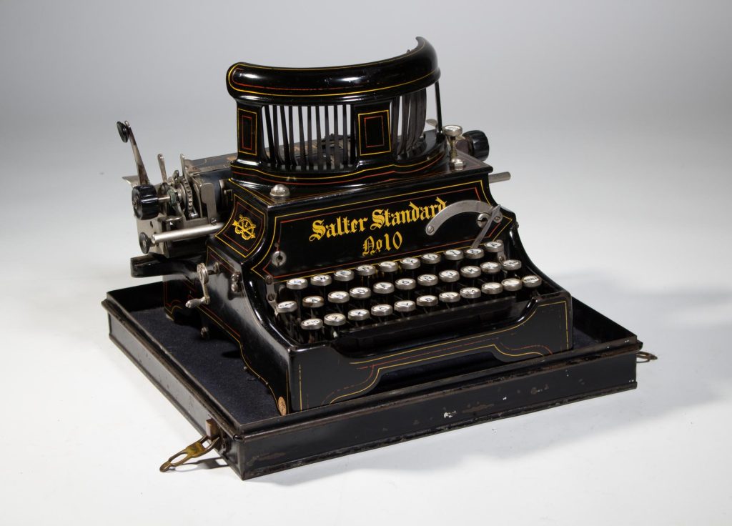 Colour photo of a black vintage typewriter with open carriage.
