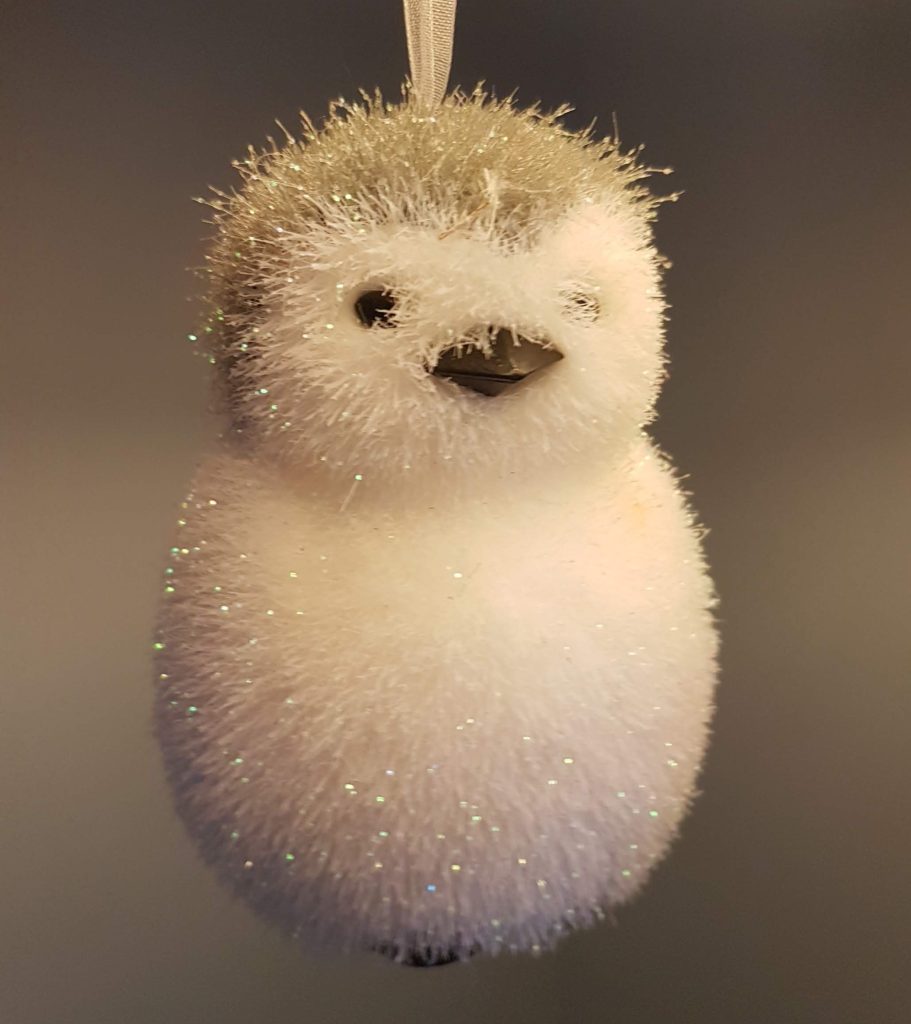 Small penguin figurine, very fluffy and sparkly and shaped like a snowman.