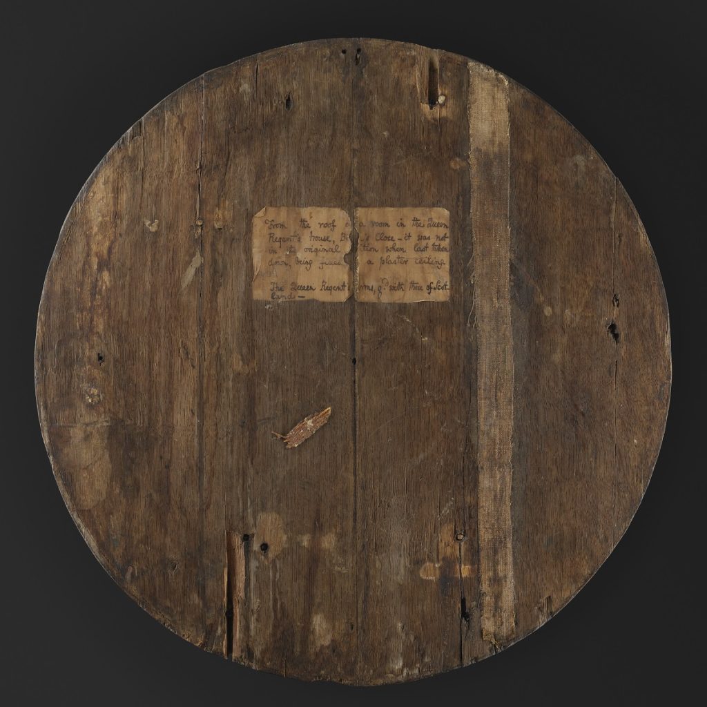 Back of the oak roundel. Flat and plain with no decoration except a small faded rectangle with black writing in it.