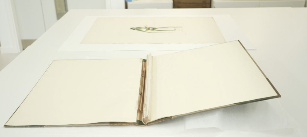 Colour photo of an large open book binder on a table.