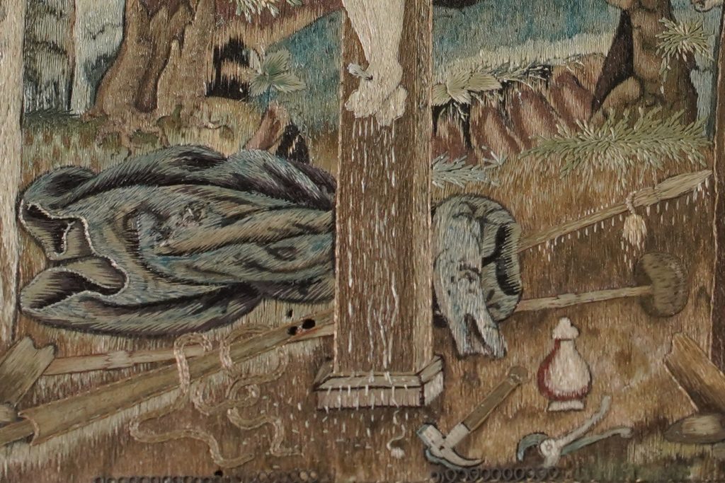 Detail showing some of the Instruments of the Passion which symbolise the stages of Christ’s journey in the days before his death. Leaves of grass and drops of blood are rendered with individual stitches.