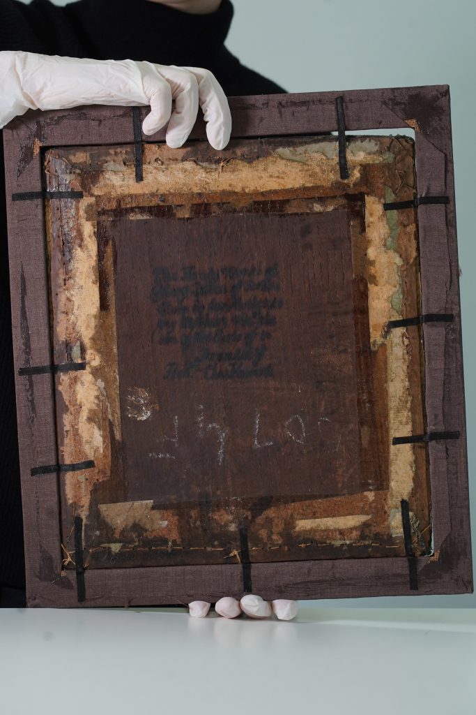 Reverse of the oak panel with writing on it.