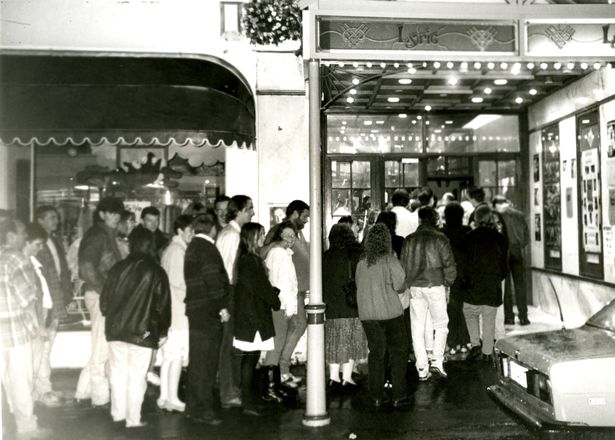 Black and white photo of people queuing to get into the cinema to see Jurassic Park in 1993.