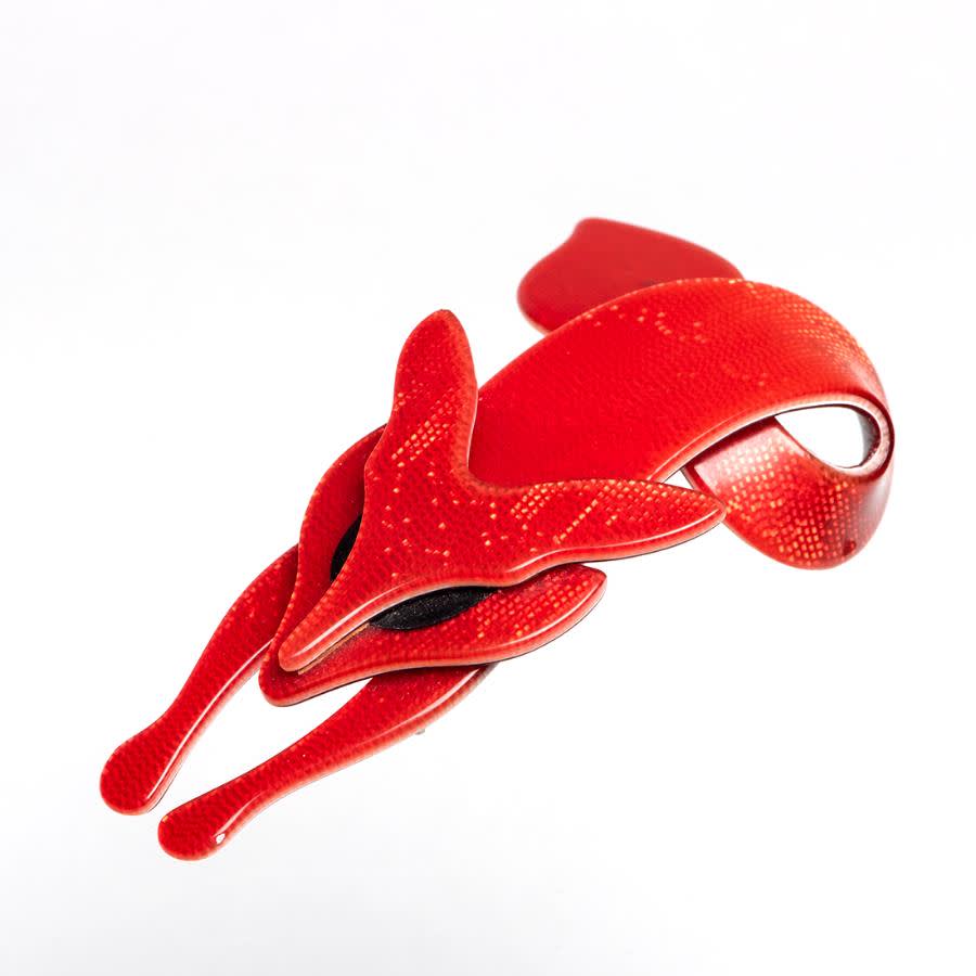 A red acrylic fox brooch.