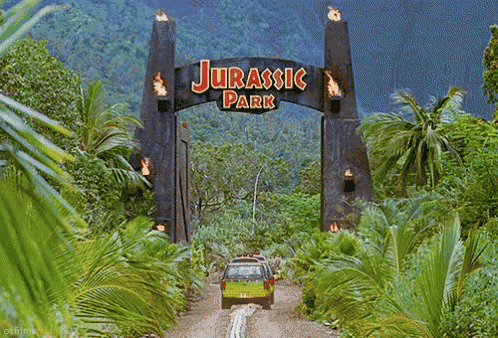 GIF of the Jurassic Park gates with cars driving through them.