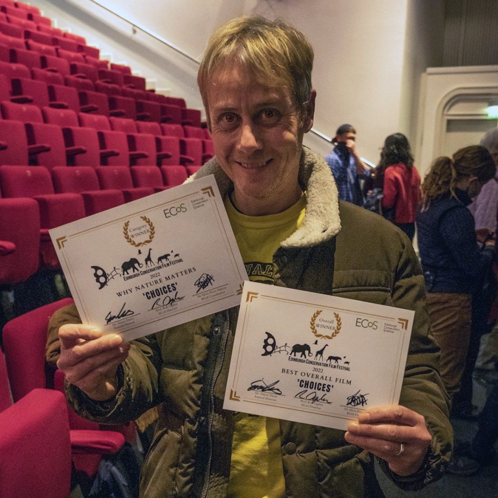 Photo of Mark holding his two certificates.