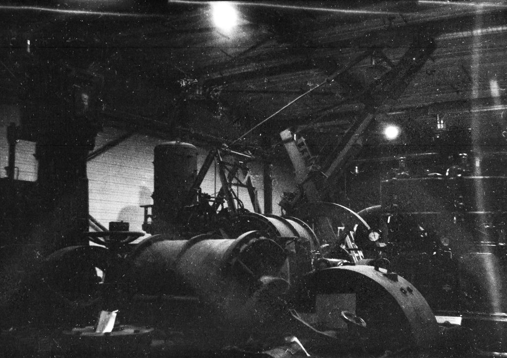 Black and white photograph of some large machinery in a storage facility.