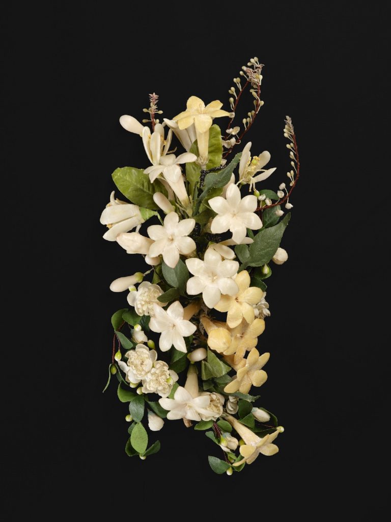 Brooch in the form of a flower bouquet, with many white flowers mixed among green leaves and pearl-like drops.