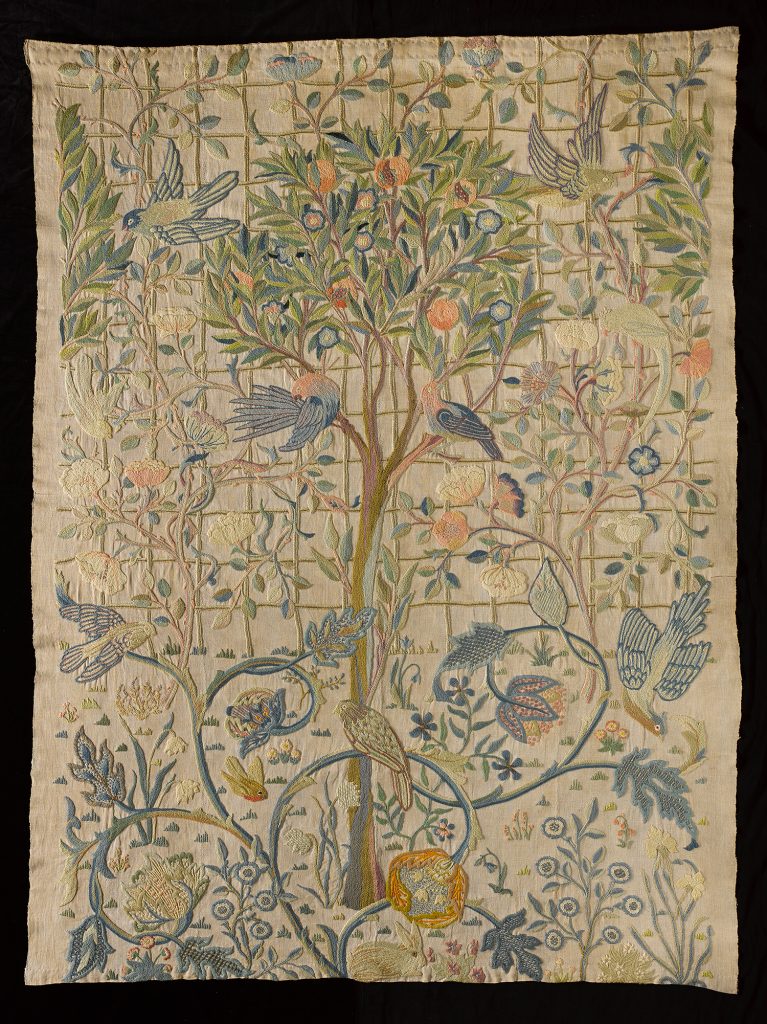 Embroidered hanging of wool on linen depicting a pomegranate tree, roses and other flowers, foliage and birds.