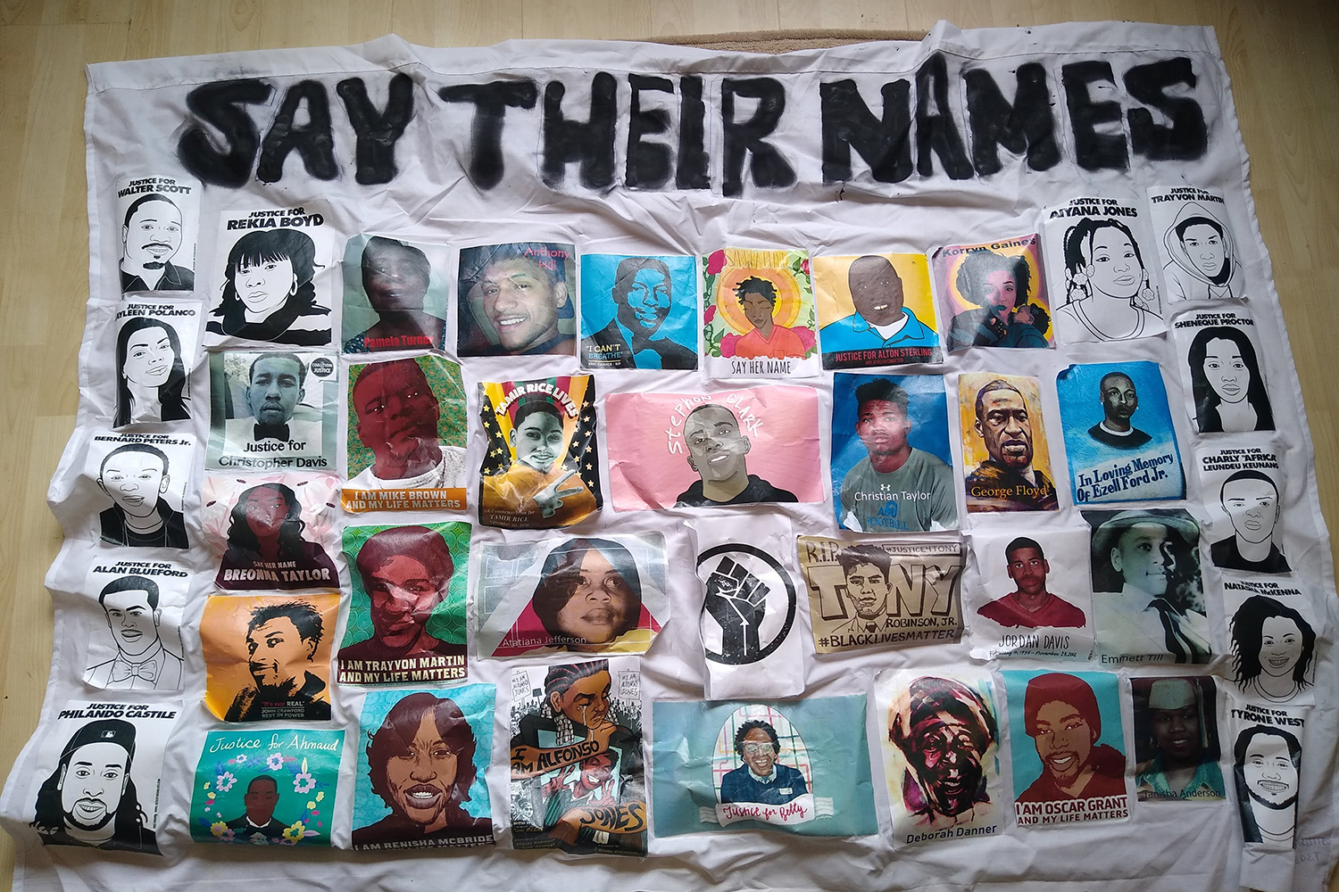 A bedsheet with illustrations of the faces of Black victims of brutality, with their names underneath.