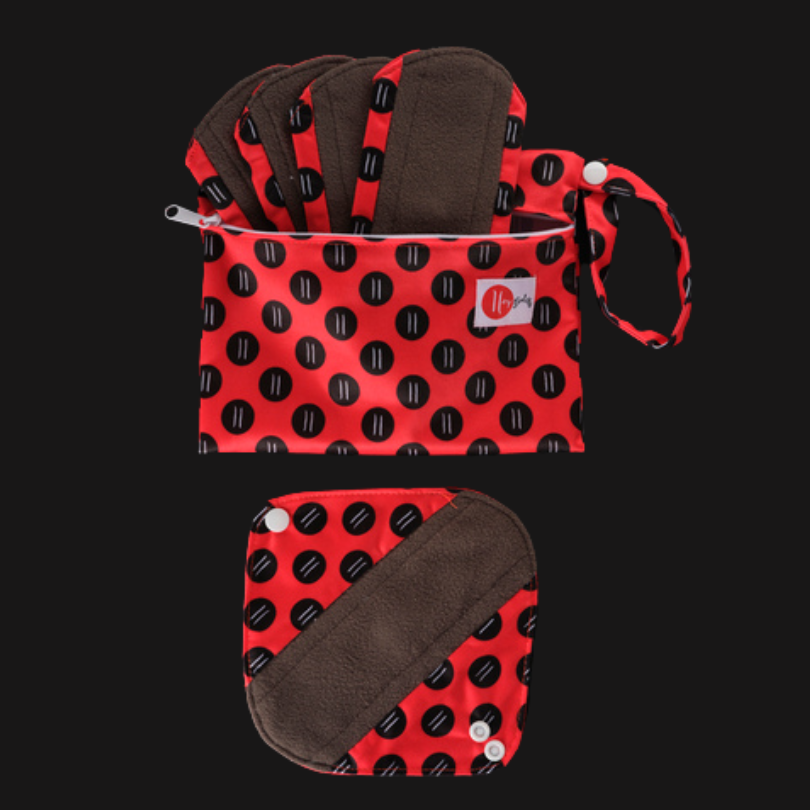 A red zip-up bag with several red, black, and brown panty liners sticking up out of it. Below the bag is an unfolded, square-shaped panty liner with a brown strip diagonally across it, a red base, and black dots.
