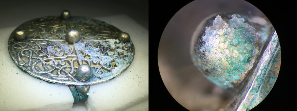 Side-by-side views through a microscope of the brooch. On the left you see it in full with a translucent gel applied to it. On the right is an extreme closeup of one of the metal studs partly covered in the gel. 